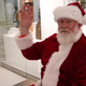 Santa Claus raises his hand as he awaits his biometric scan for entry into the United States (US Customs and Border Protection screenshot via YouTube)